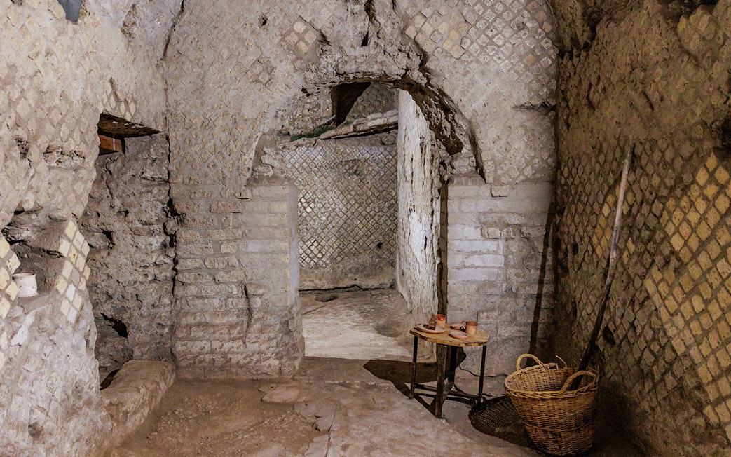 Underground passageway in Neapolis Sotterrata with ancient stone walls and artifacts.