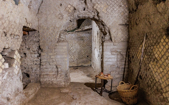Underground passageway in Neapolis Sotterrata with ancient stone walls and artifacts.
