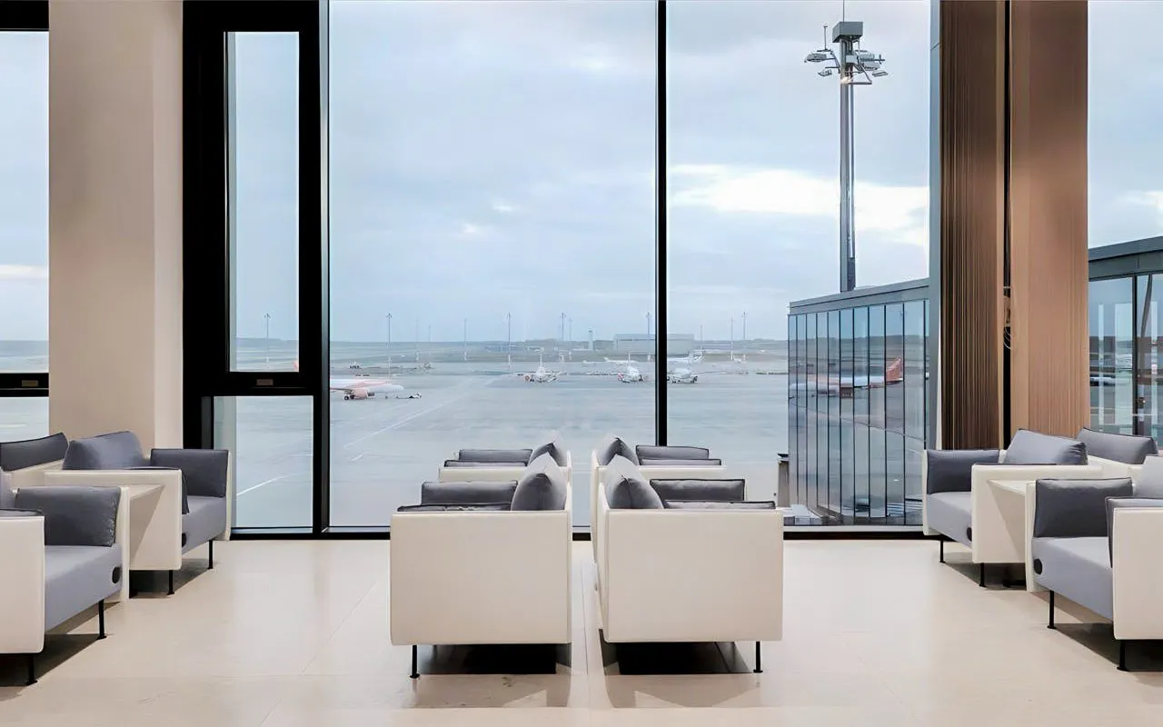 Seating area in BER Lounge Tempelhof at Berlin Brandenburg Airport with runway view.