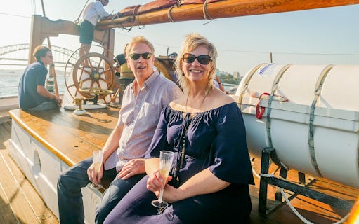 Couple enjoying a Tall Ship Cruise on Sydney Harbour with the Harbour Bridge in the background.