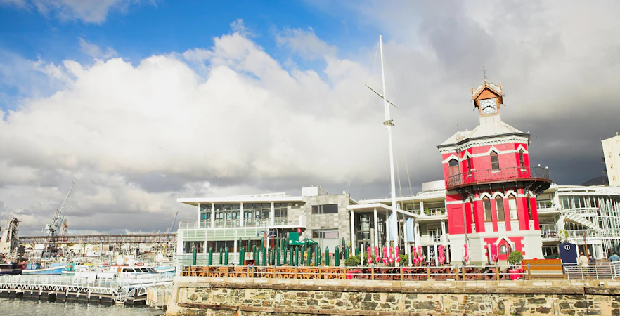 Nelson Mandela Gateway at V&A Waterfront, Cape Town with boats and historic clock tower.