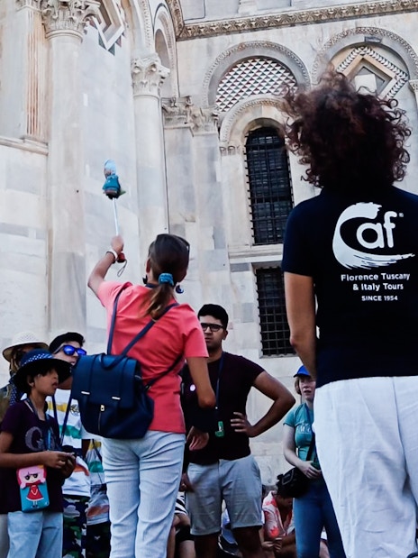 Tour group in Pisa with guide near cathedral, part of Florence to Pisa tour.