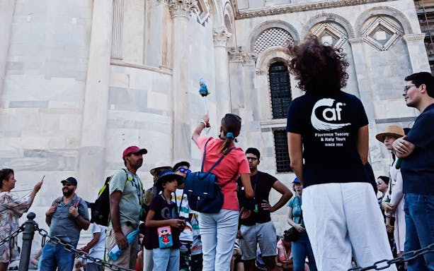Tour group in Pisa with guide near cathedral, part of Florence to Pisa tour.