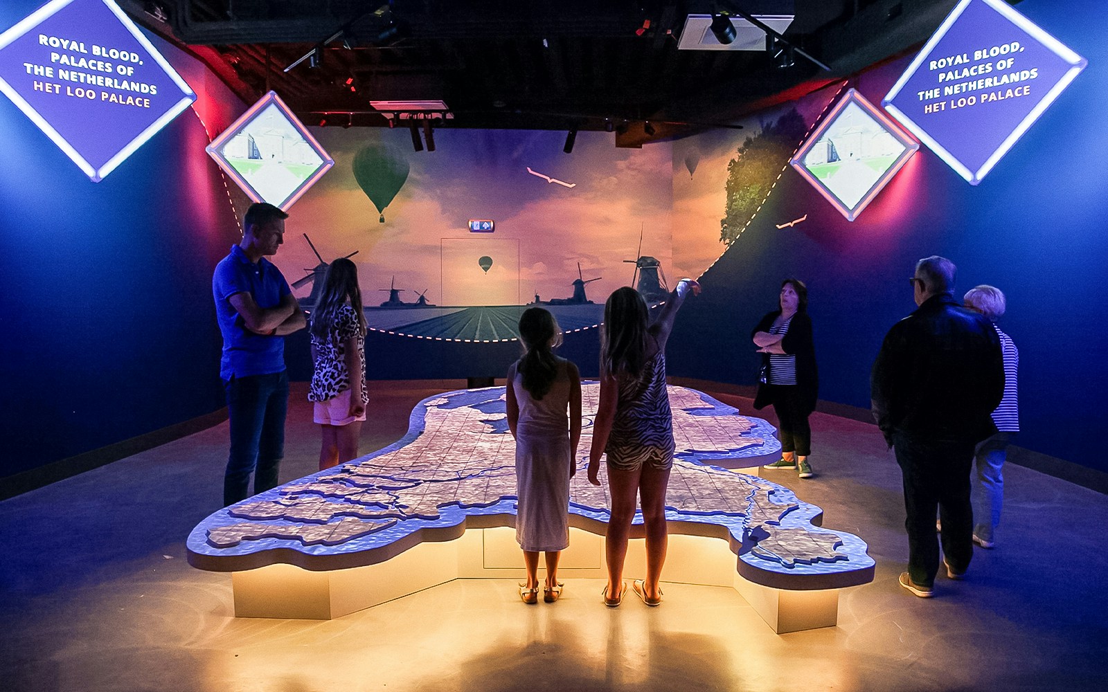 Tourists exploring interactive map at This Is Holland 5D Ultimate Flight Experience.