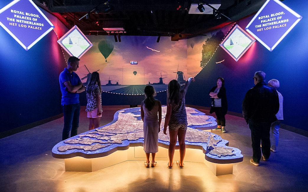 Tourists exploring interactive map at This Is Holland 5D Ultimate Flight Experience.