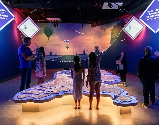 Tourists exploring interactive map at This Is Holland 5D Ultimate Flight Experience.