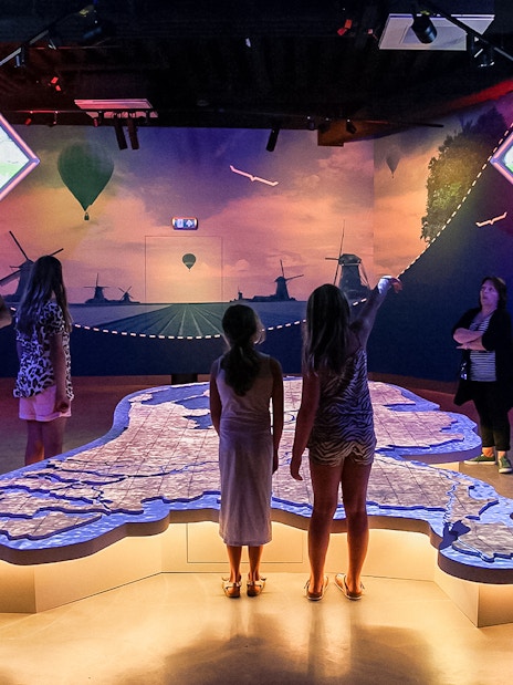 Tourists exploring interactive map at This Is Holland 5D Ultimate Flight Experience.