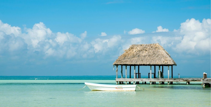 Boat near a thatched-roof pier on Isla Holbox, Mexico.