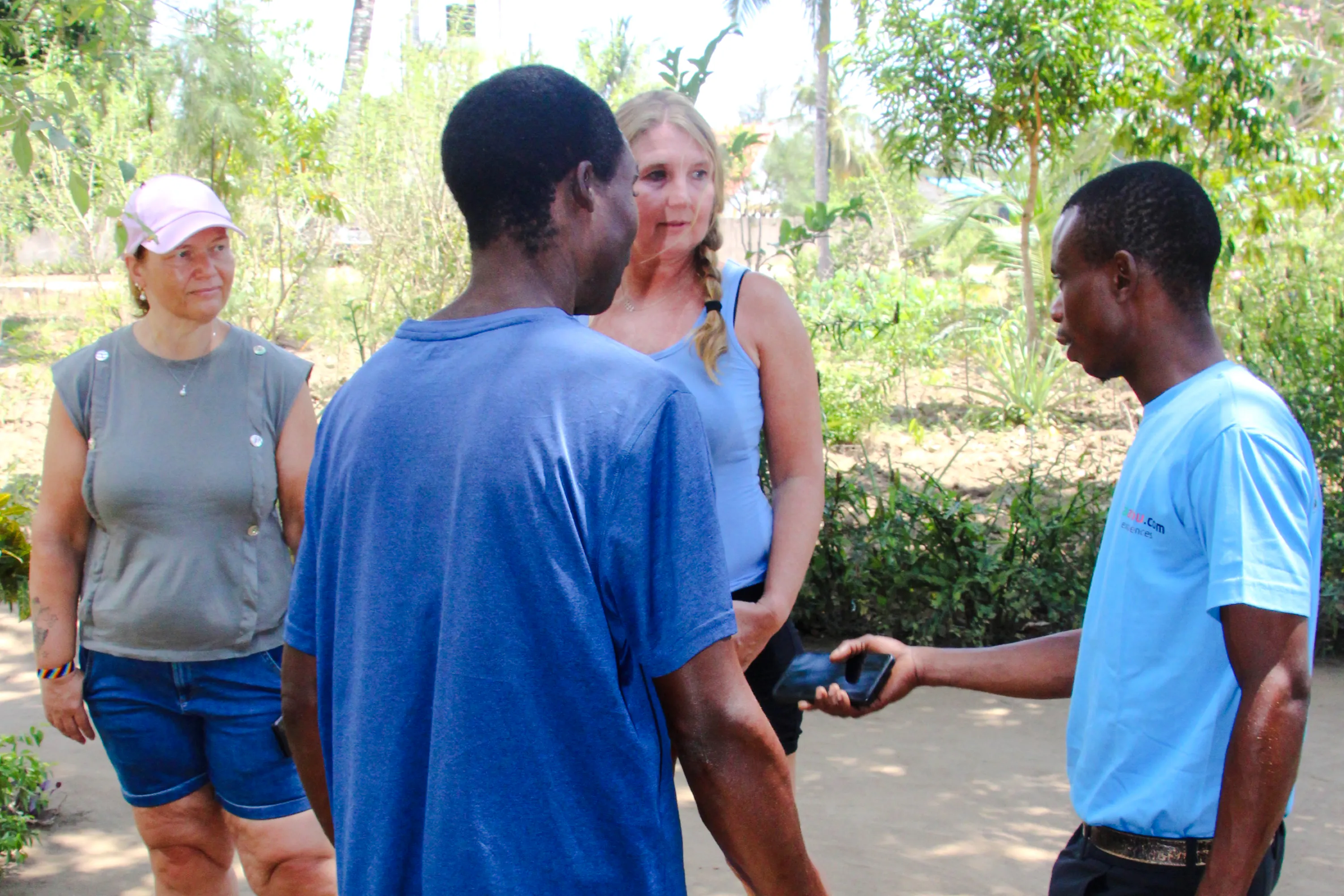 Tourists interacting with a local guide during the Giriama cultural dance show and village tour in Diani Beach.