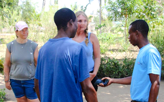 Tourists interacting with a local guide during the Giriama cultural dance show and village tour in Diani Beach.