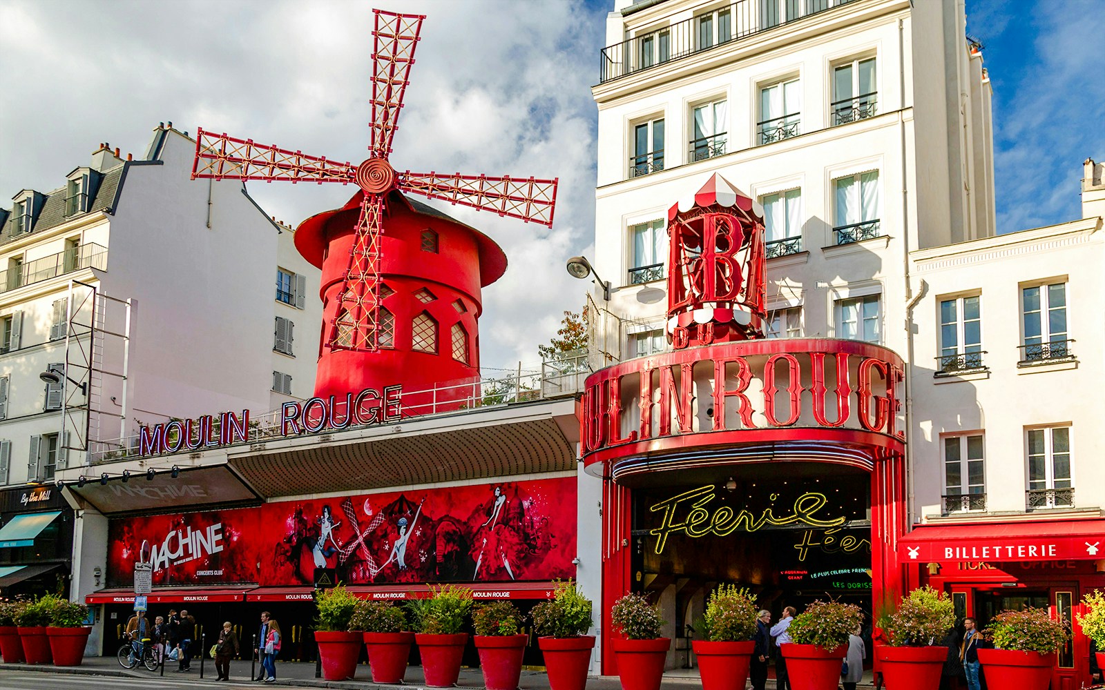 Moulin Rouge entrance with iconic red windmill in Paris, France.