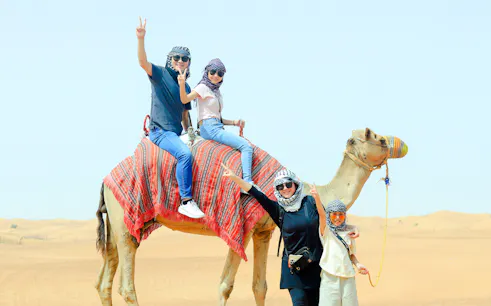 Camel ride in Dubai desert during private evening safari.