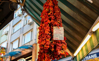 Dried stuffed peppers hanging in an Istanbul market during a food tour.