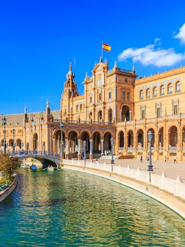 Plaza de España in Seville with canal and Spanish flag, near María Luisa Park.