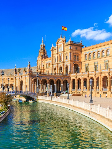 Plaza de España in Seville with canal and Spanish flag, near María Luisa Park.