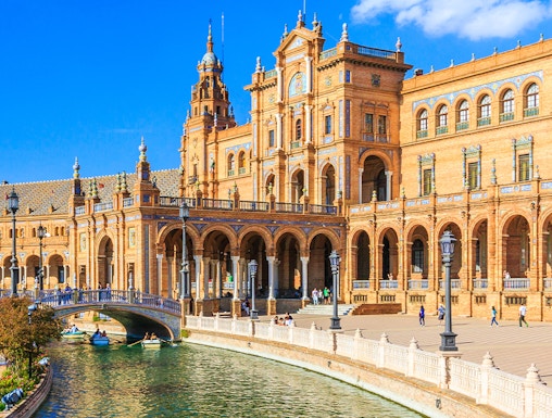 Plaza de España in Seville with canal and Spanish flag, near María Luisa Park.
