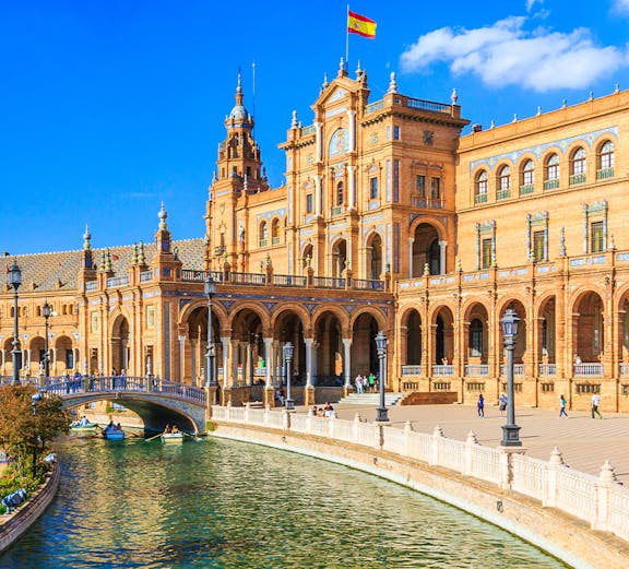 Plaza de España in Seville with canal and Spanish flag, near María Luisa Park.