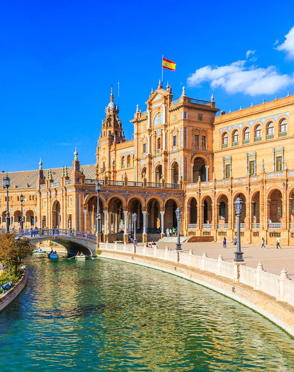 Plaza de España in Seville with canal and Spanish flag, near María Luisa Park.
