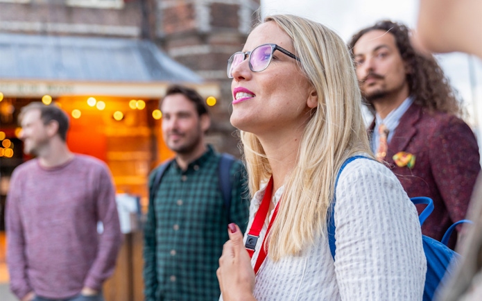 Tour group exploring Amsterdam's Red Light District with a guide.