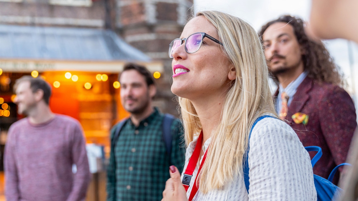Tour group exploring Amsterdam's Red Light District with a guide.