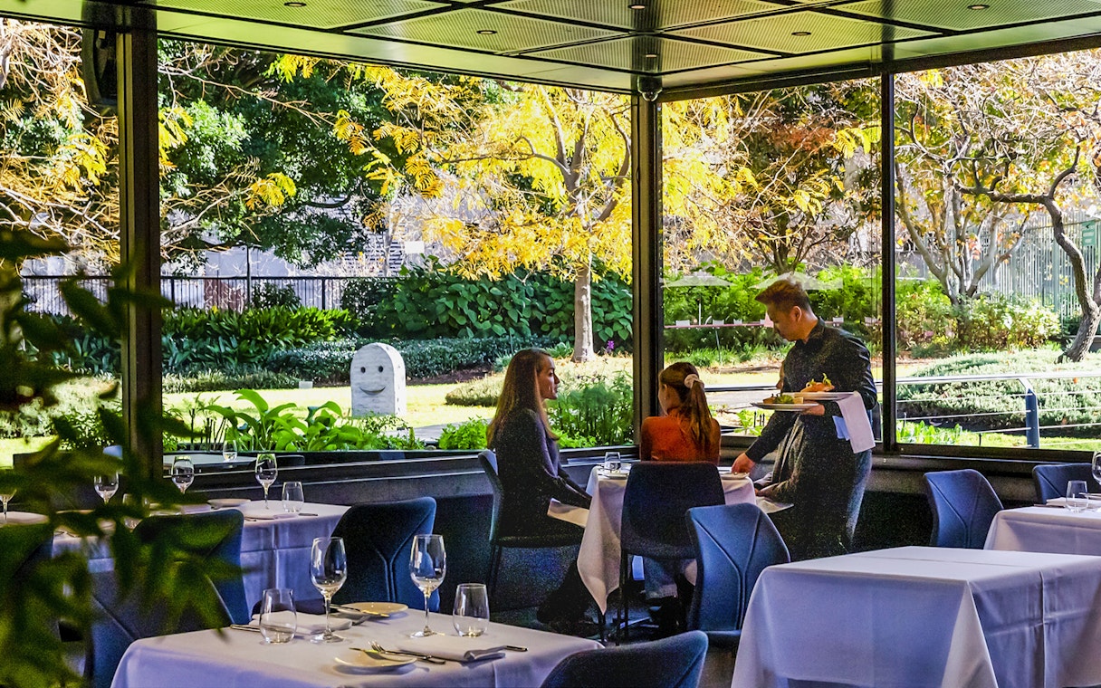 Visitors dining at Garden Restaurant, NGV International, Melbourne, with garden view.
