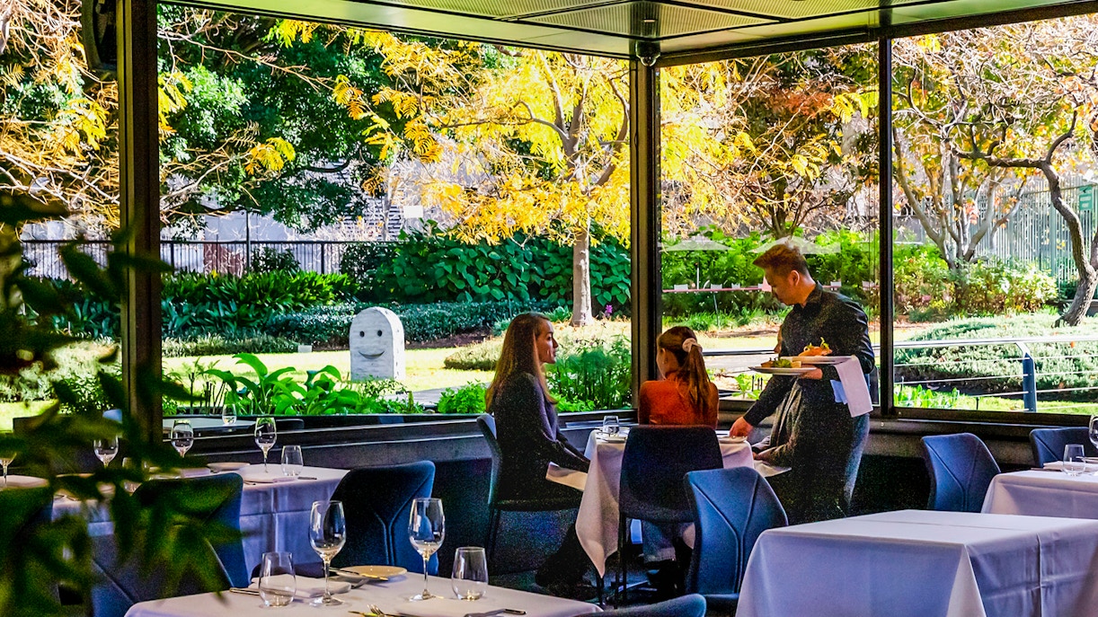 Visitors dining at Garden Restaurant, NGV International, Melbourne, with garden view.