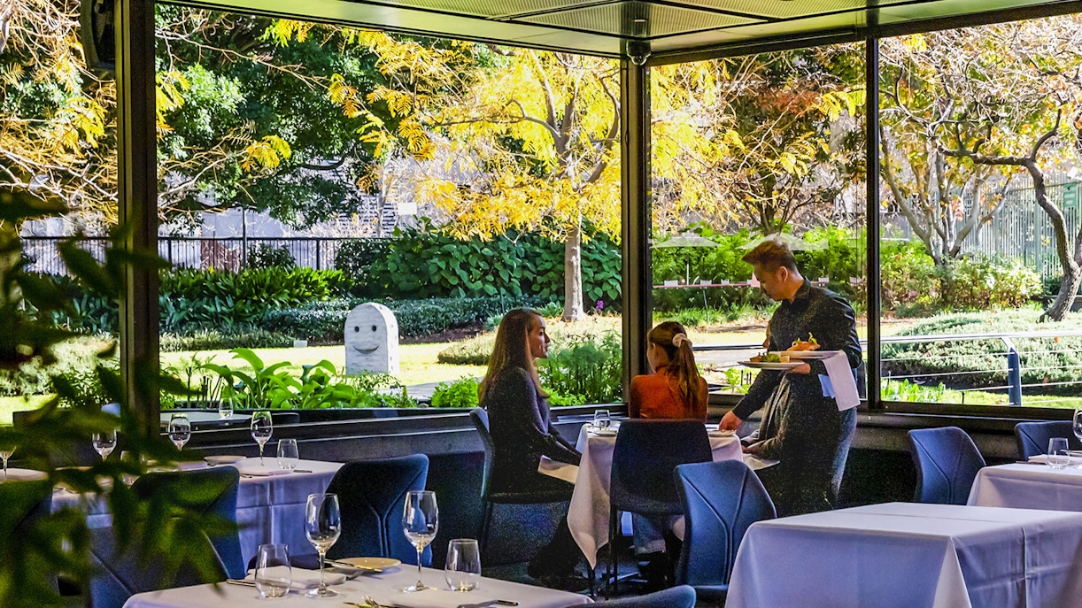 Visitors dining at Garden Restaurant, NGV International, Melbourne, with garden view.