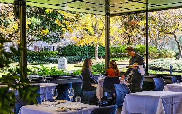 Visitors dining at Garden Restaurant, NGV International, Melbourne, with garden view.