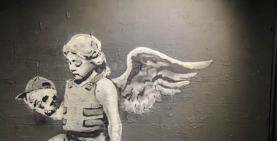 Angel holding a skull artwork at Banksy Museum, Amsterdam.