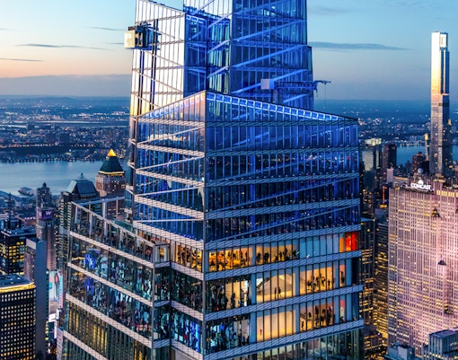 SUMMIT One Vanderbilt building in New York City at dusk with illuminated skyline.