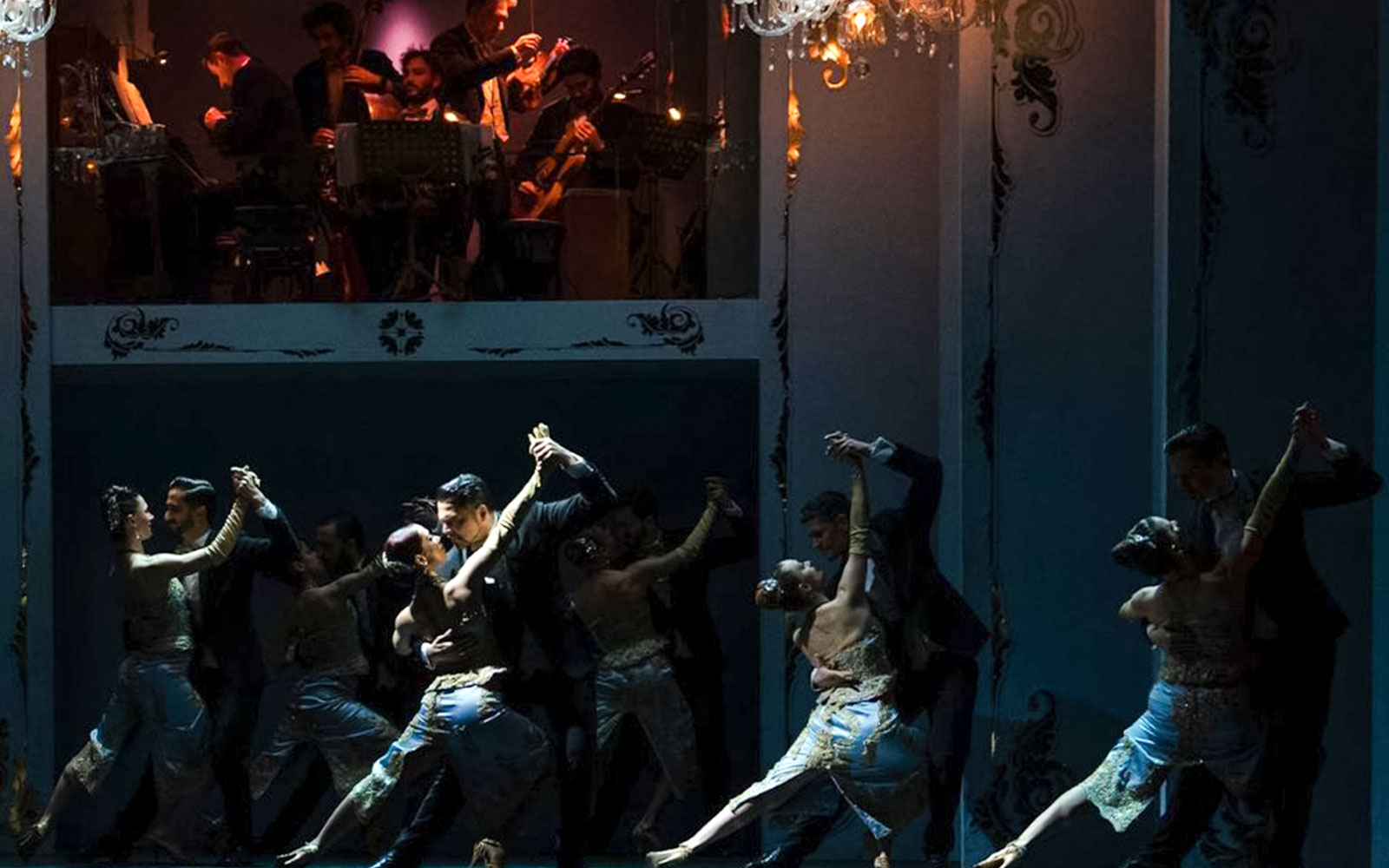 Tango dancers performing at Café de los Angelitos with live musicians in Buenos Aires.