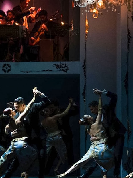 Tango dancers performing at Café de los Angelitos with live musicians in Buenos Aires.