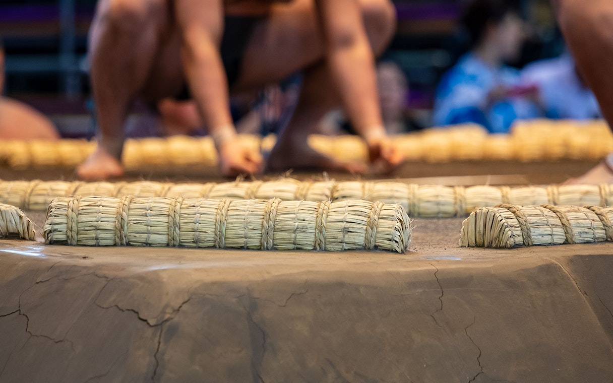 Sumo wrestlers preparing on the straw ring in Tokyo tournament.