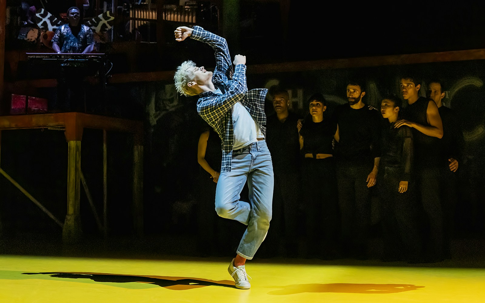 Performer dancing energetically on stage during Illinoise show.