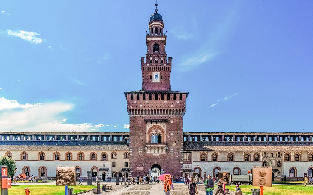 Sforza Castle courtyard with central tower in Milan, Italy, visitors exploring the historic site.