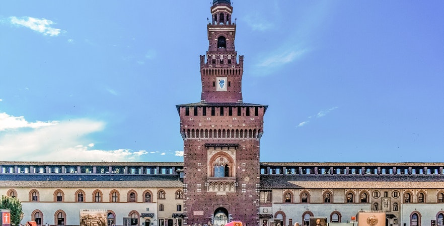 Sforza Castle courtyard with central tower in Milan, Italy, visitors exploring the historic site.
