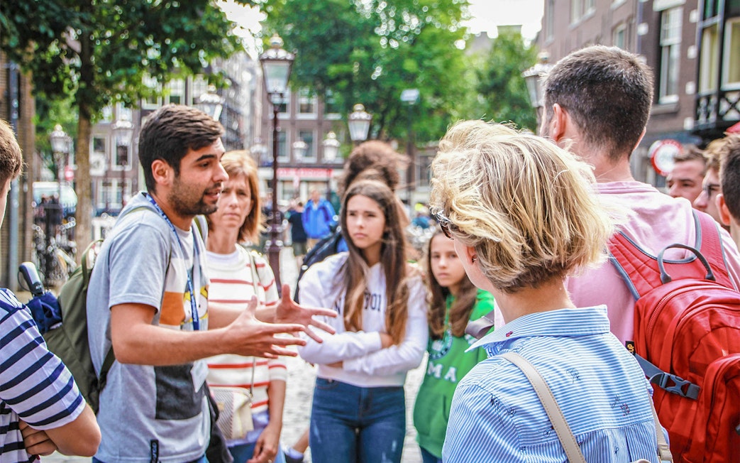 Tour guide explaining to a group in Amsterdam street during Zaanse Schans, Edam, Volendam & Marken tour.