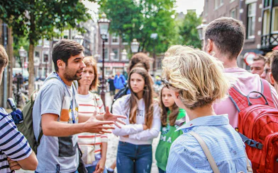 Tour guide explaining to a group in Amsterdam street during Zaanse Schans, Edam, Volendam & Marken tour.