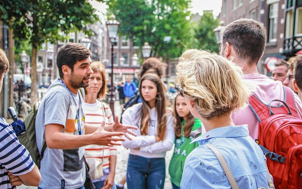 Tour guide explaining to a group in Amsterdam street during Zaanse Schans, Edam, Volendam & Marken tour.