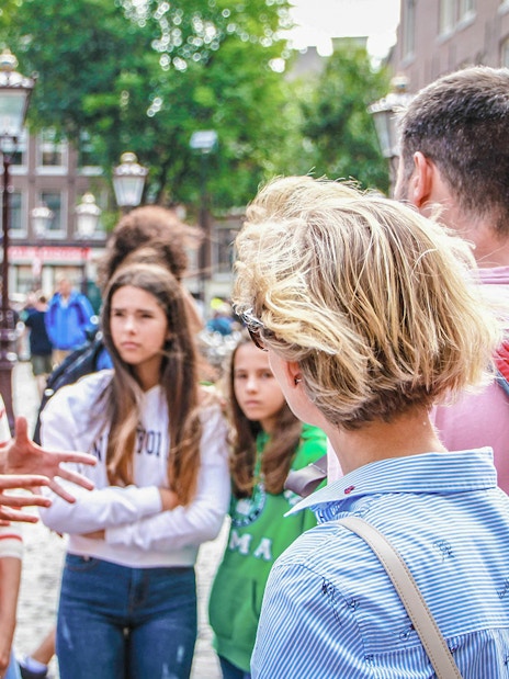 Tour guide explaining to a group in Amsterdam street during Zaanse Schans, Edam, Volendam & Marken tour.