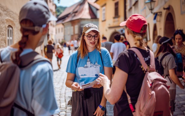 Tour guide explaining to tourists during a day trip from Prague to Český Krumlov.
