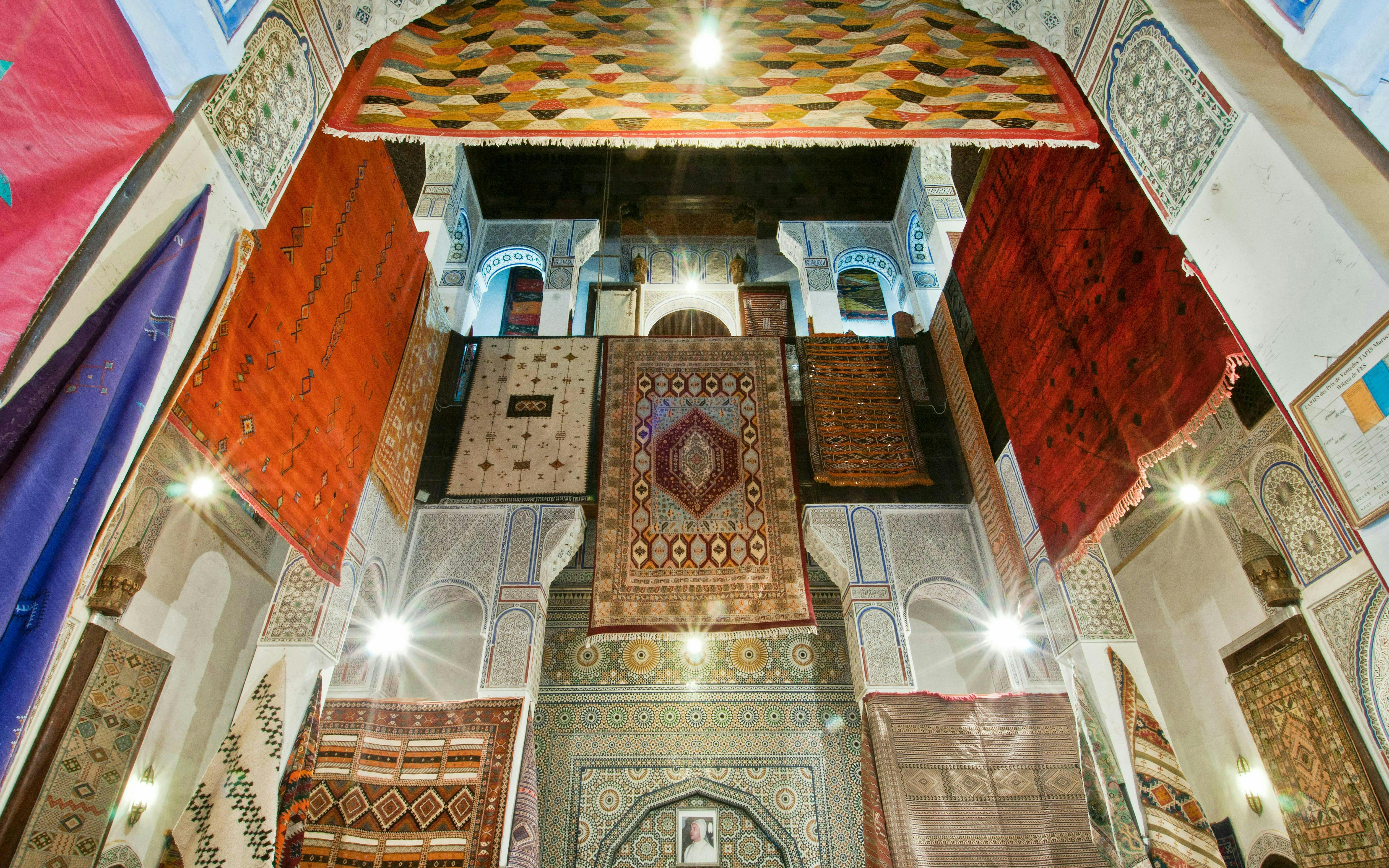 Colorful rugs hanging in a traditional shop in Fes Old Medina, Morocco.