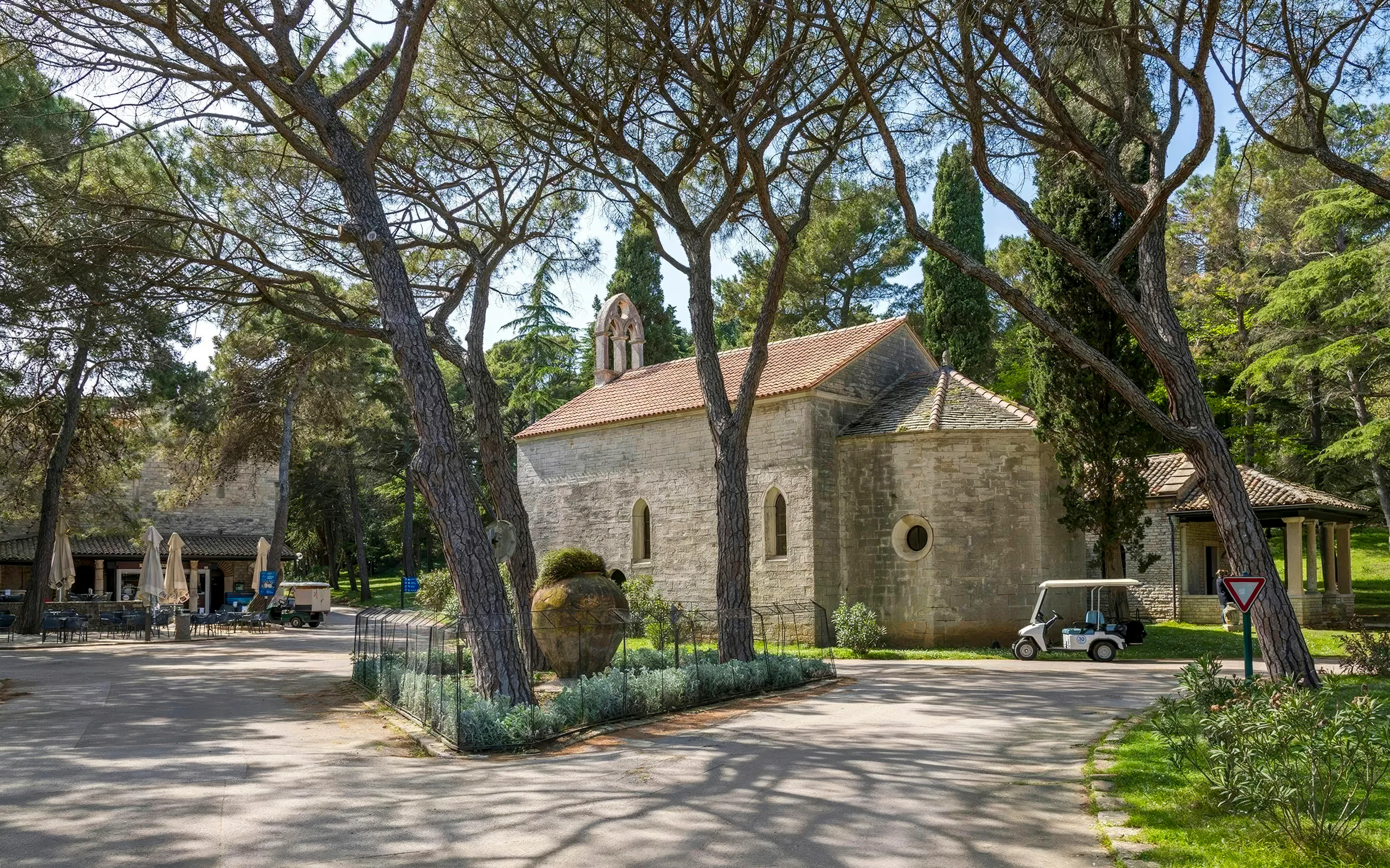 Brijuni National Park stone chapel surrounded by trees and greenery.