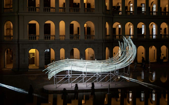 Illuminated art installation at Amsterdam Light Festival with historic building backdrop.