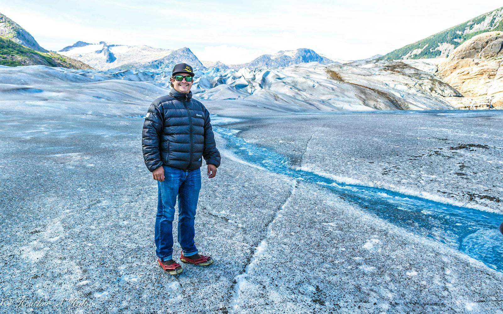 Person standing on glacier during Juneau helicopter tour with glacier landing.