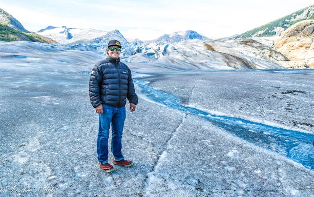 Person standing on glacier during Juneau helicopter tour with glacier landing.