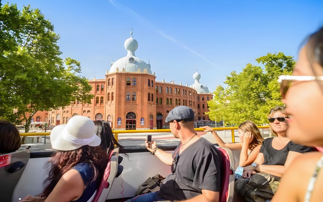 Tourists on a Hop-On Hop-Off bus in Lisbon passing by Campo Pequeno bullring.