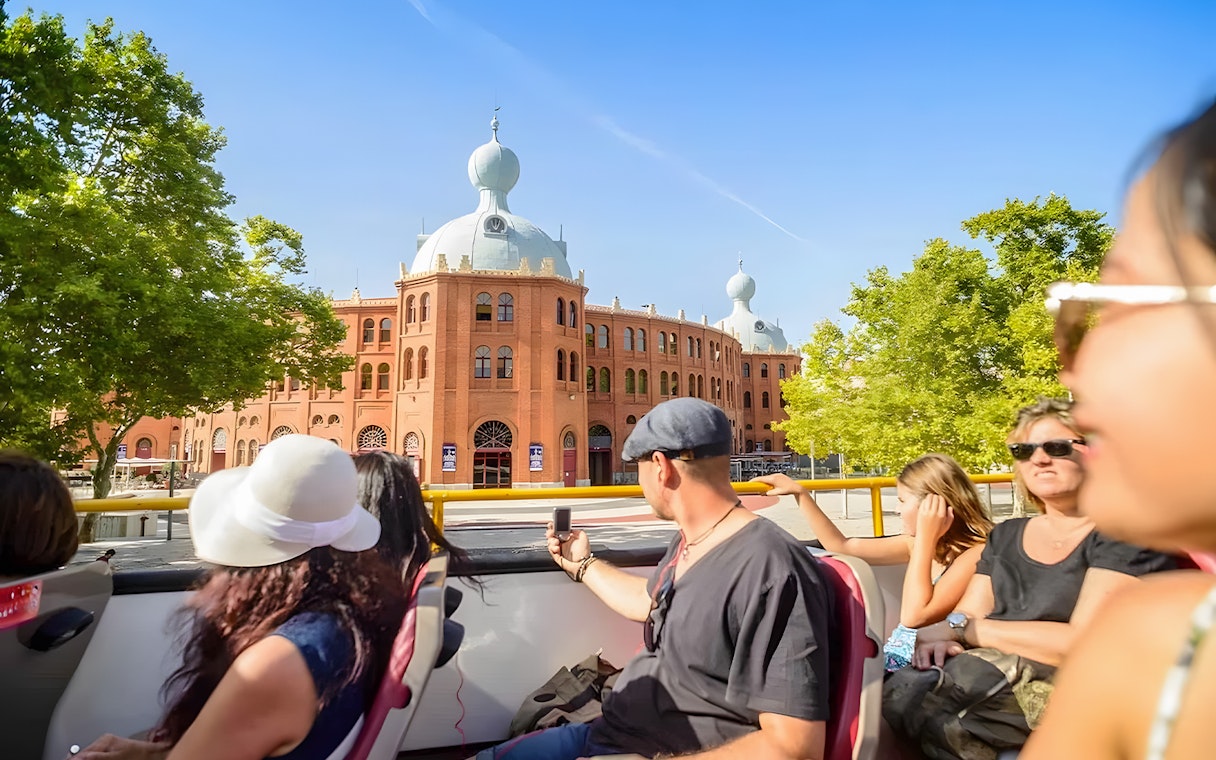 Tourists on a Hop-On Hop-Off bus in Lisbon passing by Campo Pequeno bullring.