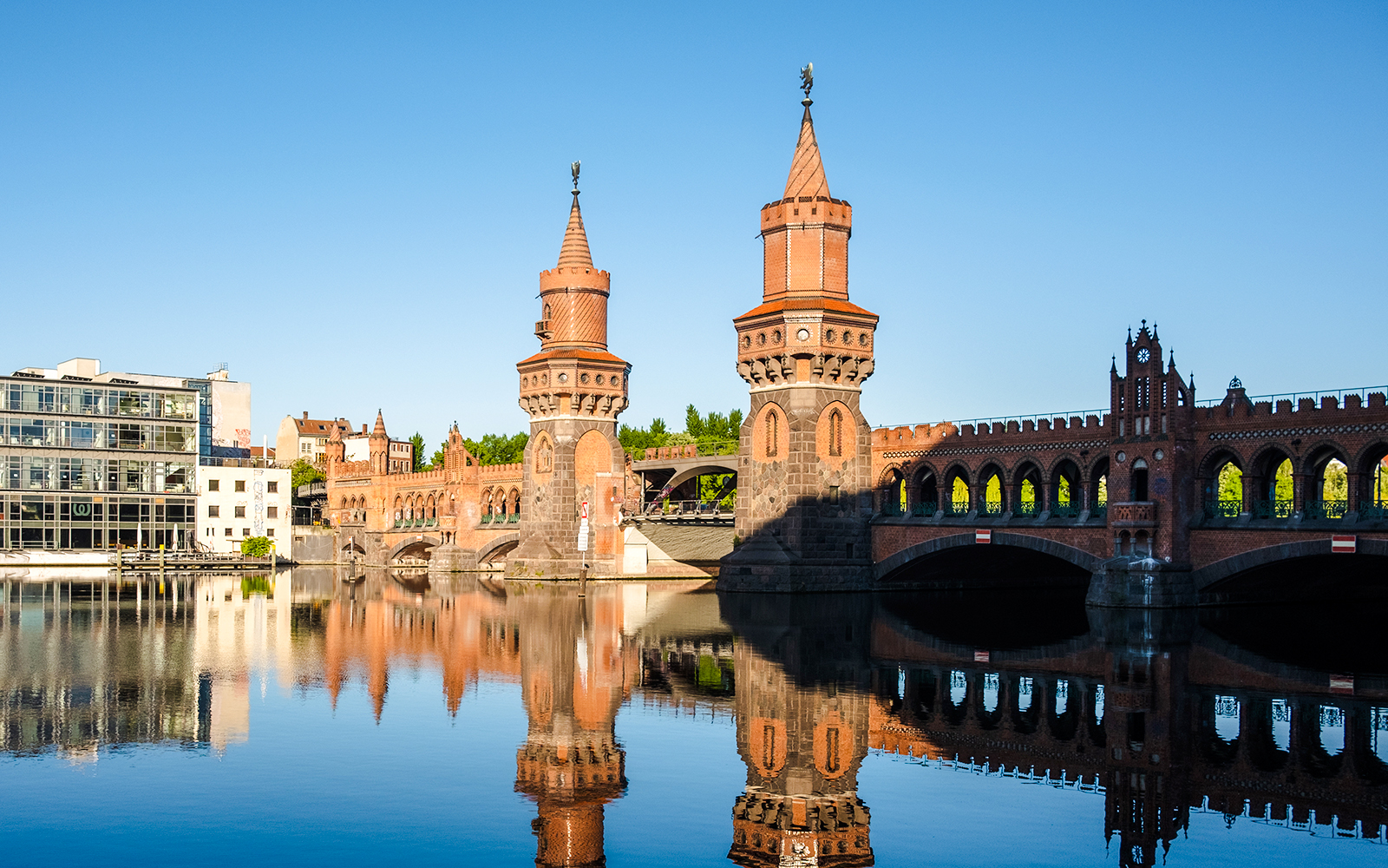 River Spree with East Side Gallery murals and boat in Berlin.