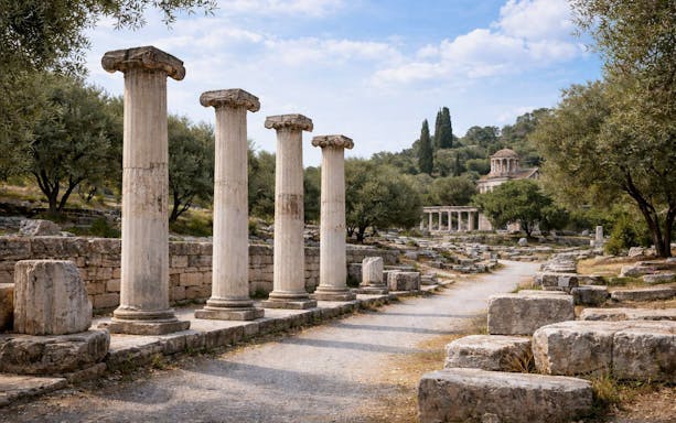 Ancient Agora ruins with columns and trees in Athens, Greece.